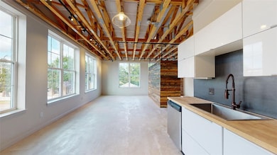 Kitchen featuring concrete floors, a sink, dishwas