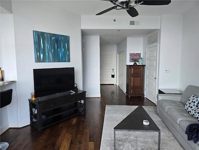 Living area with wood finished floors and ceiling fan