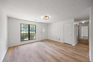 Empty room with light wood-style floors and baseboards