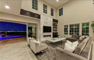 Living area with a fireplace, a towering ceiling,