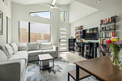 Living room with a ceiling fan, a high ceiling, a