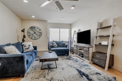 Living area with ceiling fan, light wood finished floors, baseboards, and recessed lighting