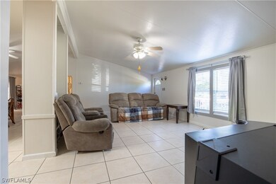 Living room featuring ceiling fan and light tile f