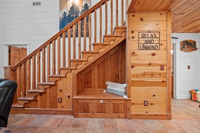 Stairway with wood walls, wooden ceiling, and stone finish flooring