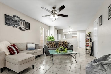 Living room featuring ceiling fan with notable cha
