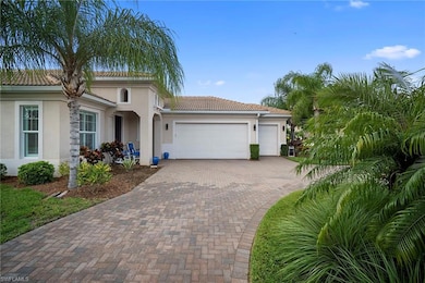 View of front of house featuring an attached garage, a tile roof, stucco siding, and decorative driveway