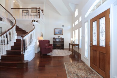 As you enter the home, the formal living room is to your right, with soaring ceilings and rich, warm wood floors.