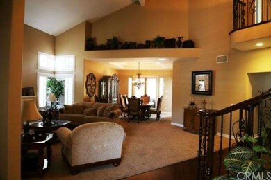 Spacious living and dining room with high ceiling.