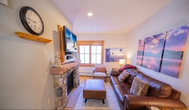 Living area featuring baseboard heating, wood fini