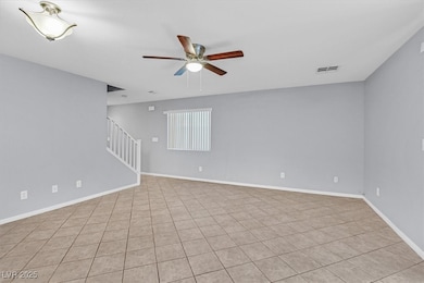 Unfurnished room with ceiling fan, stairway, and l