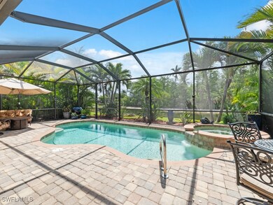 View of pool with glass enclosure, a patio area, and a pool with connected hot tub