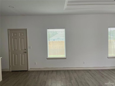 Spare room featuring wood tiled floors and plenty of natural light