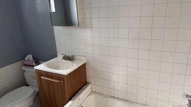 Bathroom featuring tile walls, a bathtub, and vanity