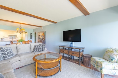 Living area with visible vents, beam ceiling, and 