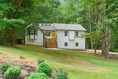 Back of property with a lawn and a shingled roof