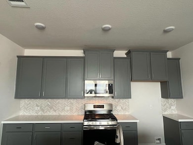 Kitchen featuring stainless steel appliances, lig