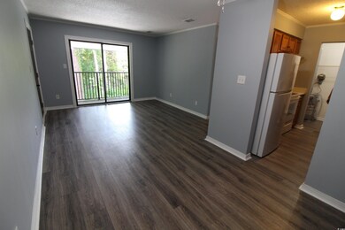 Unfurnished living room featuring a textured ceiling, dark wood finished floors, and ornamental molding