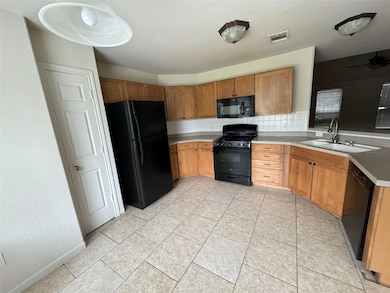 Kitchen featuring black appliances, tasteful back