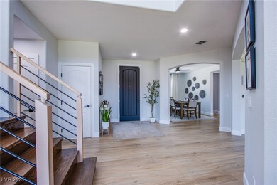 Foyer entrance with arched walkways, stairs, light