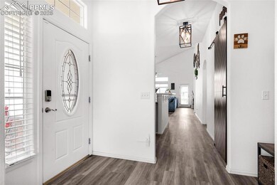 Entrance foyer featuring wood finished floors, baseboards, and a towering ceiling
