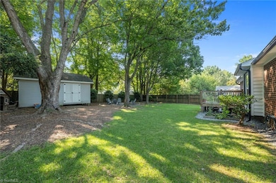Private backyard with spacious deck, fire pit area, mature trees providing ample shade and fenced for privacy.