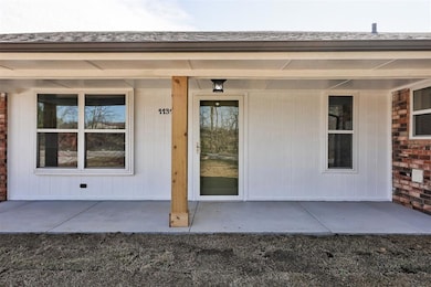 Entrance to property featuring a shingled roof and