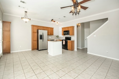 Kitchen featuring backsplash, black appliances, brown cabinets, light tile patterned floors, and ornamental molding
