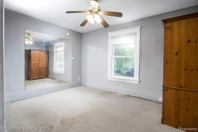 Unfurnished bedroom with light colored carpet and a ceiling fan