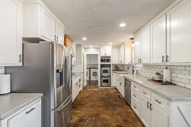 Kitchen with white cabinets, washing machine and c