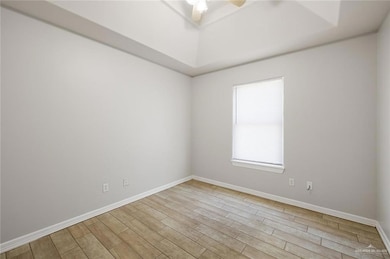 Empty room featuring light wood finished floors and ceiling fan