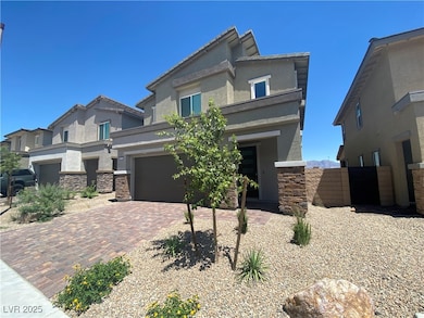 View of front of home featuring stone siding, stucco siding, decorative driveway, and a garage