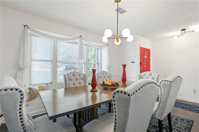 Dining space featuring a chandelier, baseboards, and wood finished floors