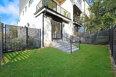Back of property featuring a fenced backyard and a balcony