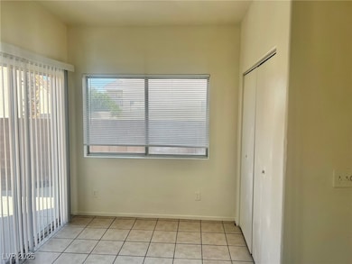 Unfurnished bedroom featuring multiple windows, light tile patterned floors, a closet, and access to outside