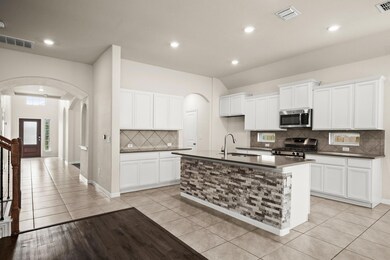 Kitchen with arched walkways, tasteful backsplash