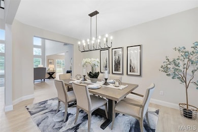 Dining room featuring light wood-style floors and a chandelier