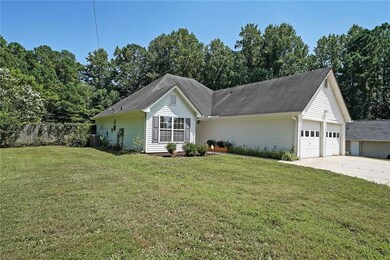 Ranch-style home featuring a garage, a front lawn, concrete driveway, and roof with shingles
