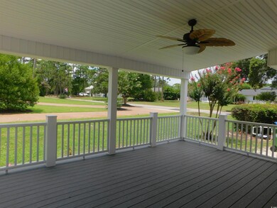 Wooden terrace with ceiling fan and a lawn