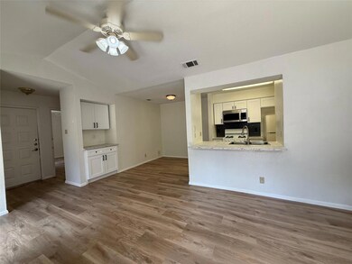 Unfurnished living room with dark wood-style floors, a ceiling fan, and lofted ceiling