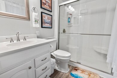 Bathroom with an enclosed shower, wood-type floori