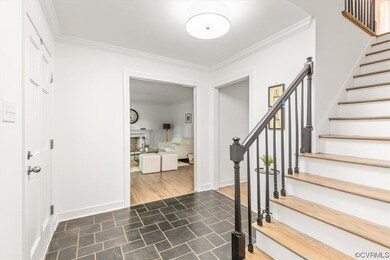 Foyer entrance featuring ornamental molding and li