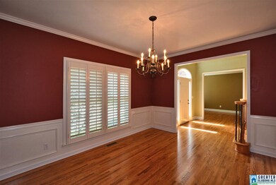 Dining room with wood shutters overlooking mature 