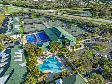 Drone / aerial view of a pool area, padel, clubhouse, restaurant, fitness area, and tennis courts