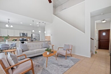 Living area featuring stairs, a high ceiling, lig