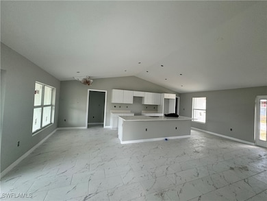 Unfurnished living room featuring lofted ceiling,