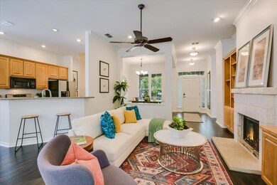 Living area with dark wood-style flooring, recessed lighting, a high end fireplace, a chandelier, and crown molding