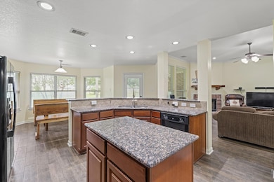 Kitchen featuring a sink, black appliances, a cen