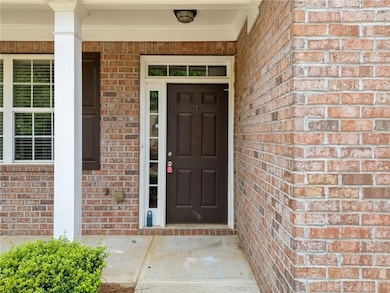 Property entrance featuring brick siding and covered porch