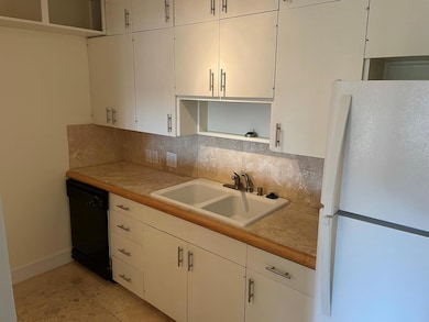 Kitchen with light countertops, dishwasher, a sin