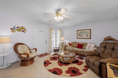 Living area featuring a ceiling fan, tile patterne